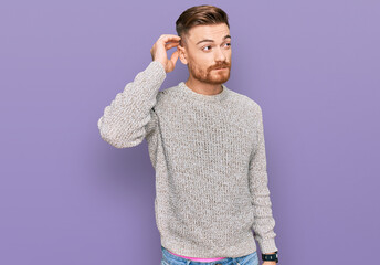 Young redhead man wearing casual winter sweater confuse and wondering about question. uncertain...