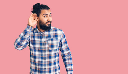 Young arab man wearing casual clothes smiling with hand over ear listening an hearing to rumor or gossip. deafness concept.