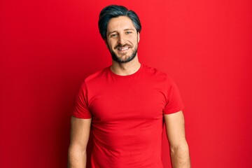 Young hispanic man wearing casual red t shirt with a happy and cool smile on face. lucky person.