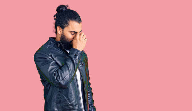 Young arab man wearing casual leather jacket tired rubbing nose and eyes feeling fatigue and headache. stress and frustration concept.
