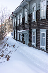 Old wooden houses under the snow. Russia. Siberia. Winter. The city of Tomsk 2021. Multifamily residential wooden houses of the 19th century.