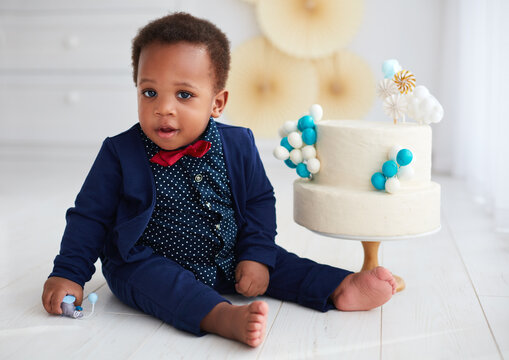 cute one year old baby boy with a birthday cake