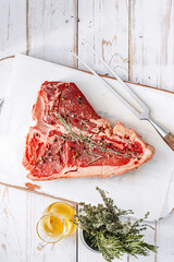 fresh and raw t-bone steak on white wooden background