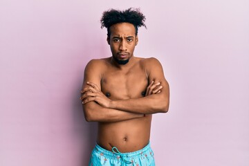 Fototapeta premium Young african american man with beard wearing swimsuit skeptic and nervous, disapproving expression on face with crossed arms. negative person.