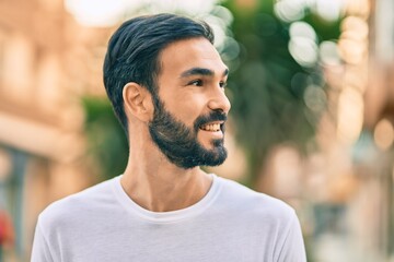 Fototapeta premium Young hispanic man smiling happy standing at the city.