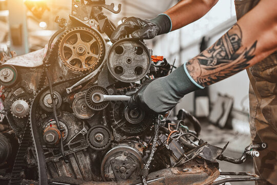 Hands Of Car Mechanic Repairs The Car Engine In Auto Repair Service.