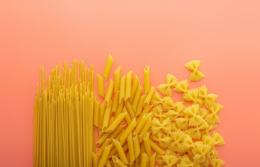 Pasta spaghetti penne farfalle on pink background