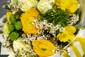 Yellow bouquet of yellow and orange flowers on grey background