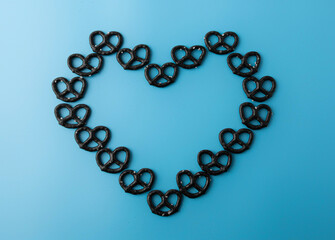 Mini black pretzels heart on light blue background