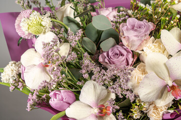 Bouquet of pink roses, alstroemeria flowers and orchids. Fresh summer flowers on gray background
