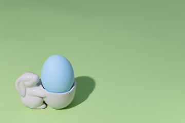 Easter egg in an egg stand on green background 