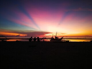 A sunset photo of a simple but happy family in an island.