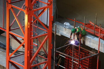 Worker are working cutting or welding steel structure, Safety uniform and work planing in workplace, Construction site, Development land and residential building in city.