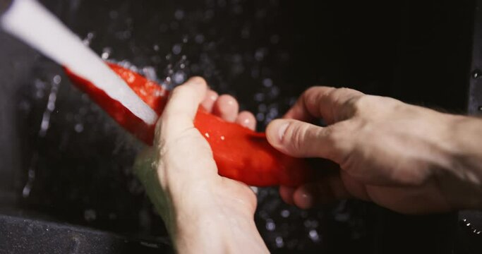 Washing red pepper in lewd way under the sink 4k slow motion footage