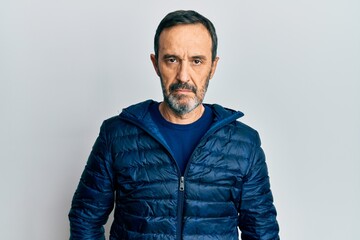 Middle age hispanic man wearing casual clothes with serious expression on face. simple and natural looking at the camera.