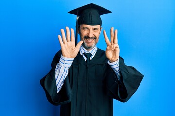 Middle age hispanic man wearing graduation cap and ceremony robe showing and pointing up with fingers number eight while smiling confident and happy.