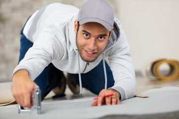 male contractor using staple gun on new flooring