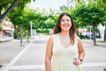 Young beautiful woman smiling happy. Standing with smile on face looking at the camera walking at town street.