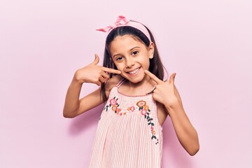Beautiful child girl wearing casual clothes smiling cheerful showing and pointing with fingers teeth and mouth. dental health concept.