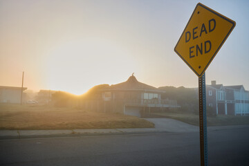 Dead End Sign against the sun. The sun is just rising. 