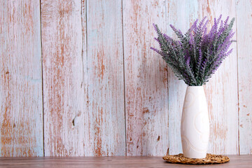 Lavender flowers in watering can, wooden background, copy space.