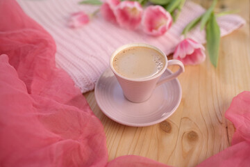 buds of spring flowers, pink tulips, a cup of cappuccino, coffee with cream on a wooden table, draped silk, concept of spring, women's lifestyle, morning mood