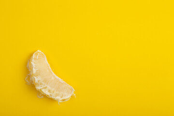 Pomelo cut pieces on yellow background close up. Fresh fruits healthy food
