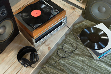 HiFi system with turntable, amplifier, headphones and lp vinyl records in a listening room - obrazy, fototapety, plakaty