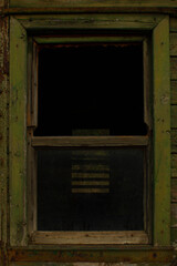 Obraz na płótnie Canvas Loft style windows on a green wood wall. A black window on an old green trailer. Loft style on the example of a window.