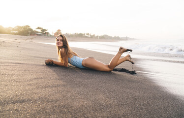 Slim woman lying on wet beach