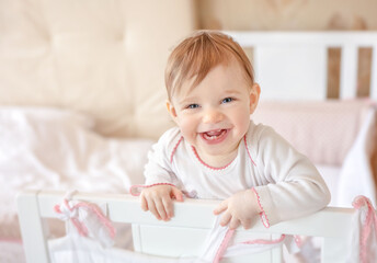 Naklejka premium Smiling baby at home. Happy child in white nursery.