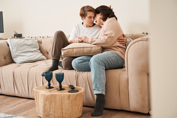 Couple in love enjoying their free time, while sitting on a couch