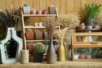 Vases with decoration items placed on a wooden shelf on table