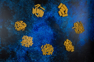 Fototapeta na wymiar Pasta varieties isolated on blue background