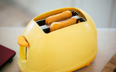 Close up photo of fresh tasty slices of toasts from the yellow toaster on the beautiful kitchen...