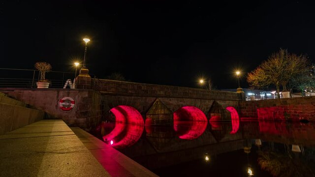 A small pedestrian bridge in the city center of Vejle, Denmark illuminated at night