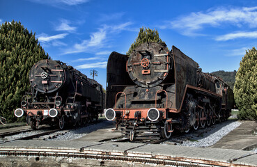Zwei alte historische Dampflokomotiven stehen auf einem Abstellgleis