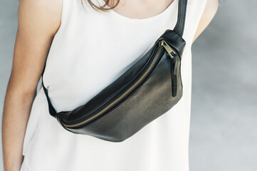 Leather Sling Purse Bum Bag Leather. Girl in a white t-shirt with a black leather banana bag chest.