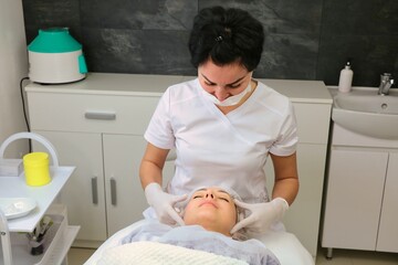 Obraz premium Preparing the face of a female patient for a cosmetic procedure