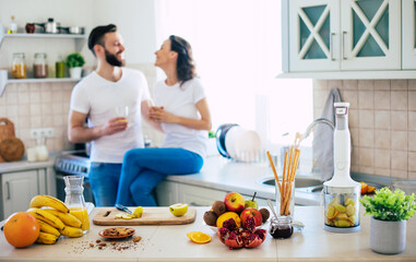 Excited happy beautiful young couple in love cooking in the kitchen and having fun together while...