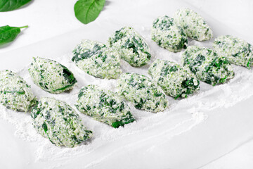 Cooking Gnudi with ricotta and spinach on white board. Italian meal