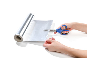 Lifehack; female hand cutting aluminum foil to sharpen scissors isolated on white background
