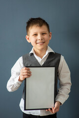 boy 8-10 years old in a white shirt on a dark background with a frame, space for text, selective...