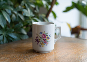 Mid century modern cups with flower bouquet on a wooden table