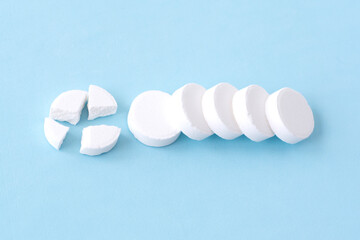 Round white medical pills on a blue background. Health concept