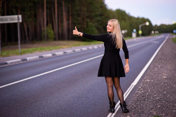 blonde girl in black dress on the road, selective focus