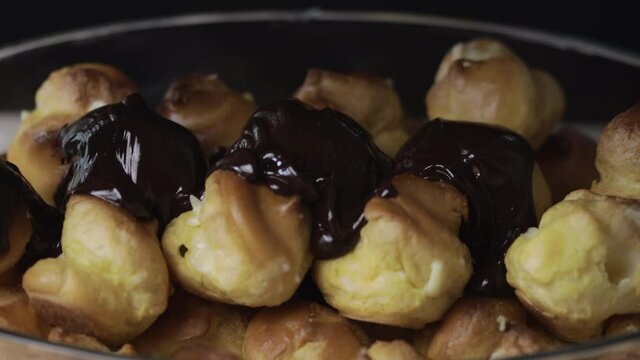 Man pastry chef pours chocolate on a cake. Closeup view. Dessert concept