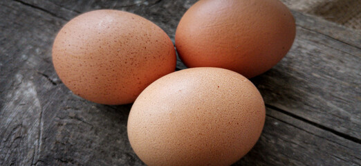 Frische Hühnereier auf altem Holzbrett