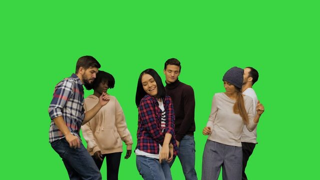 Young men and women dancing at the party on a Green Screen, Chroma Key.