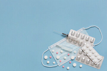 Protective face mask, pills, ampulla with vaccine, expendable syringe for vaccination. Treatment concept various infection and virus diseases.